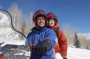 Photo of a Couple Snowmobiling and Utilizing Backcountry Snowmobiling Tips