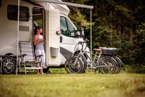 Guest standing outside an RV with bicylces lined up.