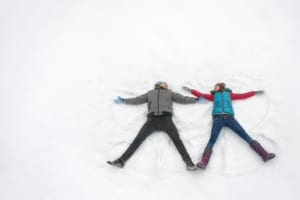 Couple making snow angels.