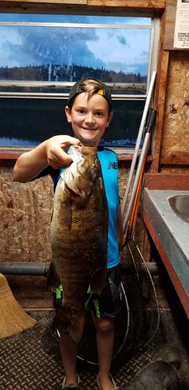 Young boy holding a large fish.